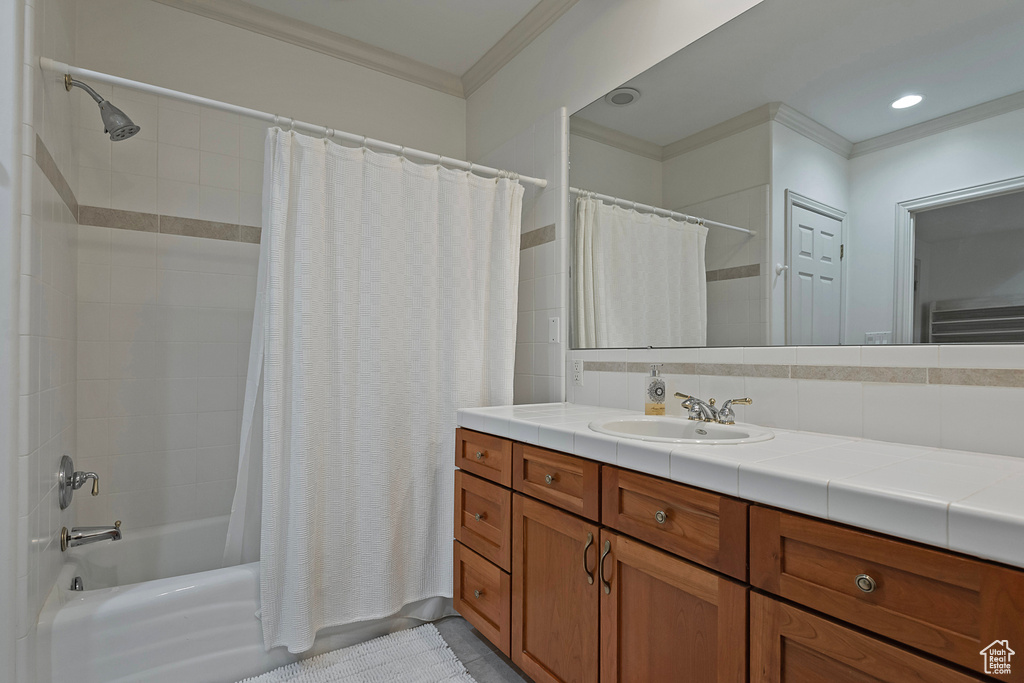 Bathroom featuring ornamental molding, shower / tub combo with curtain, tasteful backsplash, and large vanity