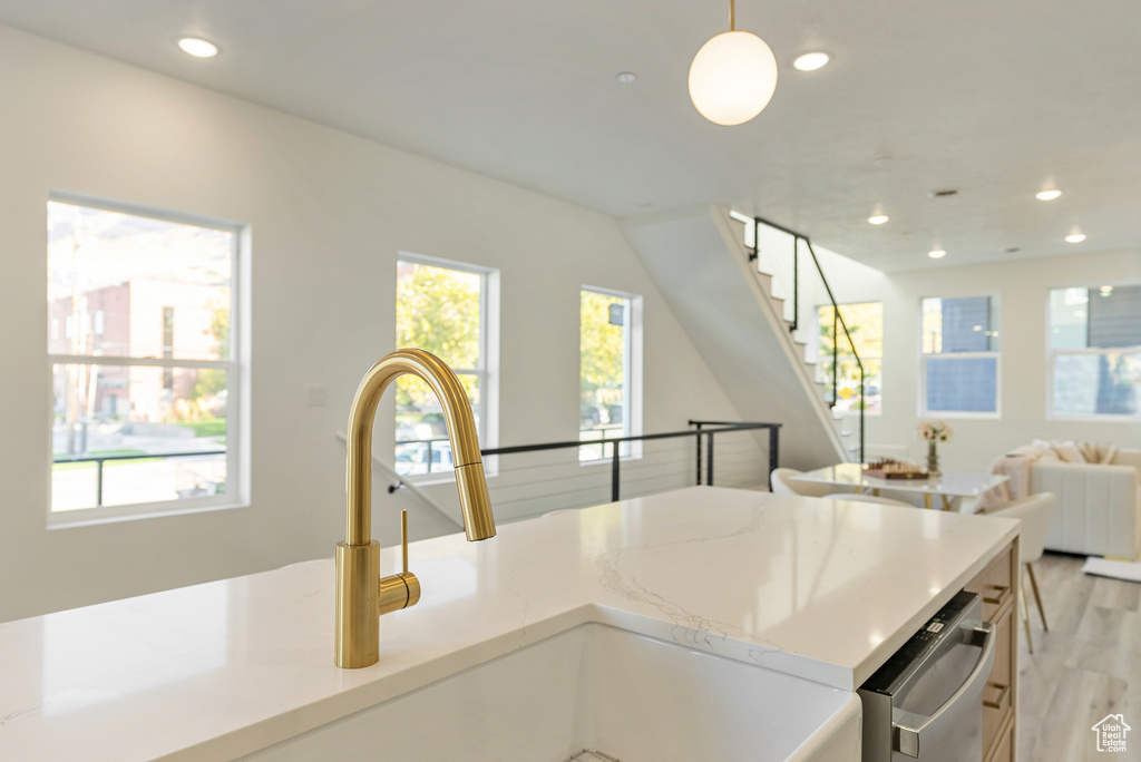 Kitchen featuring sink, hanging light fixtures, and light hardwood / wood-style floors