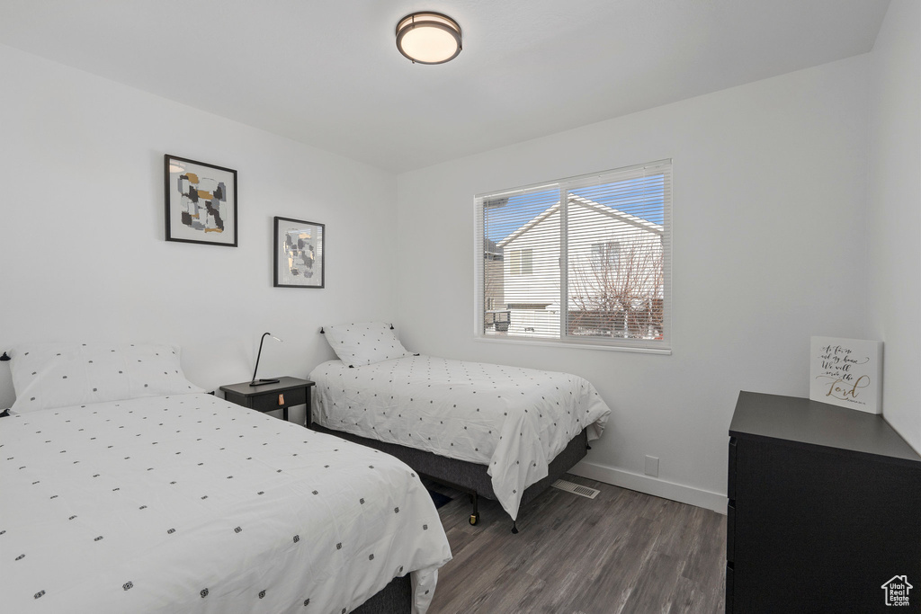 Bedroom with dark hardwood / wood-style flooring