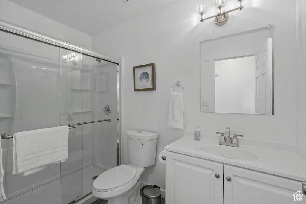 Bathroom with vanity, an enclosed shower, and toilet