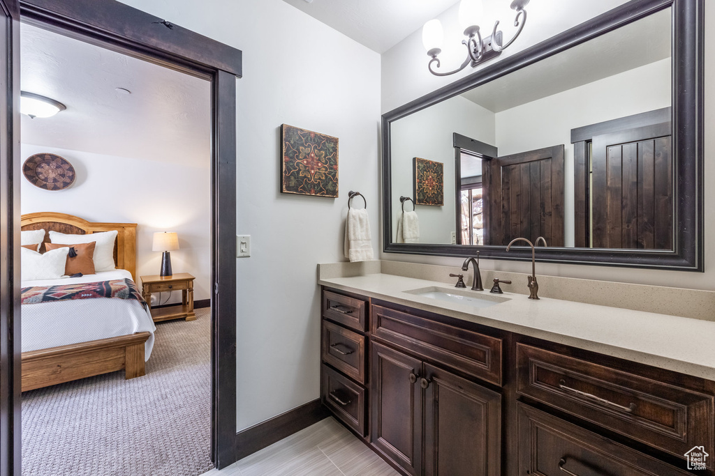 Bathroom with vanity with extensive cabinet space and tile flooring