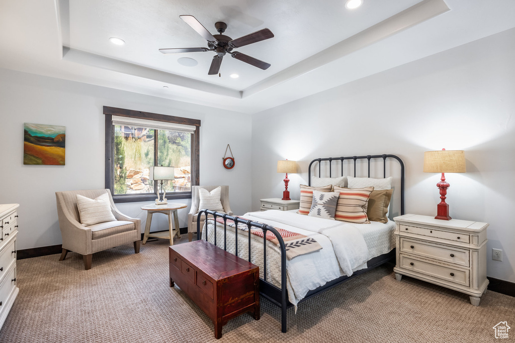 Bedroom with carpet, a raised ceiling, and ceiling fan