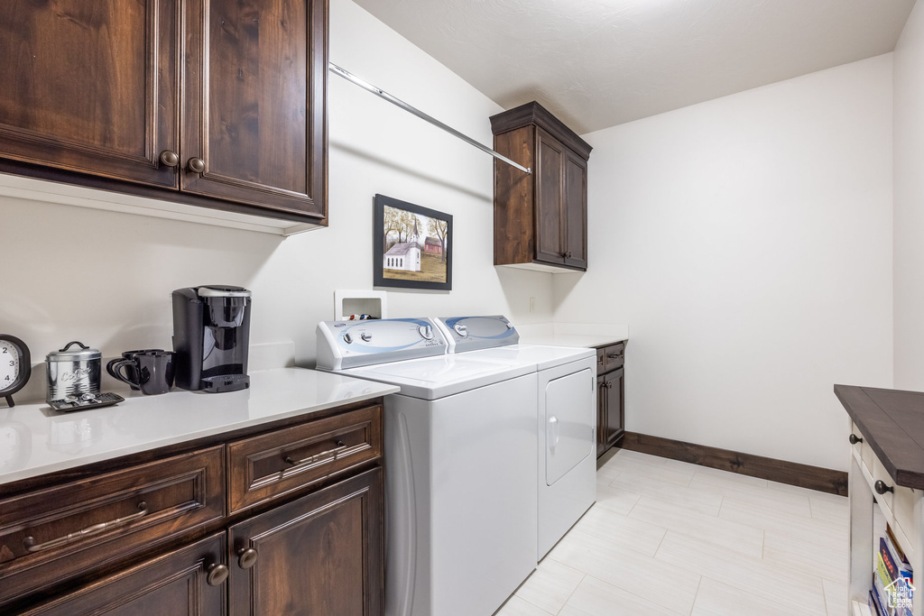 Washroom with washer and dryer, cabinets, washer hookup, and light tile floors