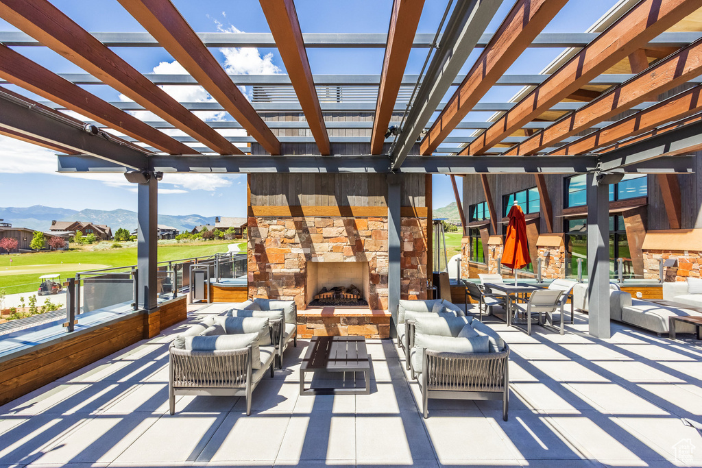 View of patio featuring a pergola, an outdoor living space with a fireplace, and a mountain view