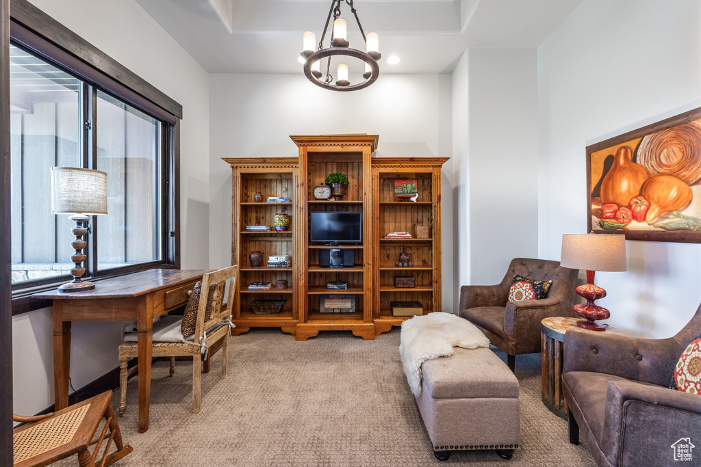 Carpeted office space with a notable chandelier