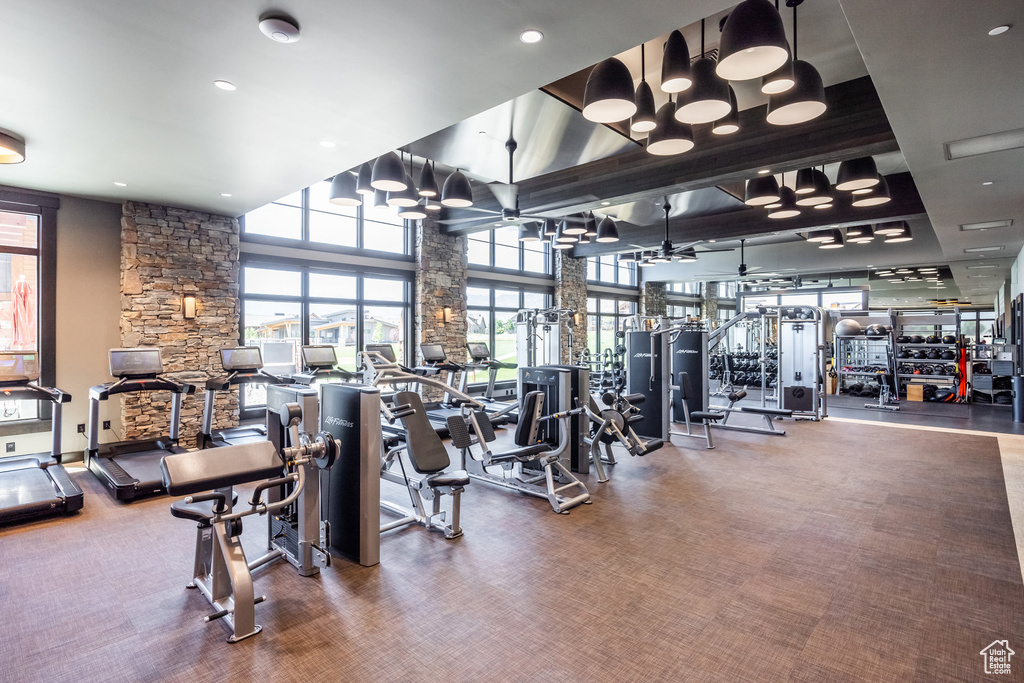 Workout area with a high ceiling, carpet, and ceiling fan