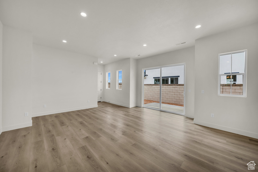 Unfurnished living room with light hardwood / wood-style flooring and plenty of natural light