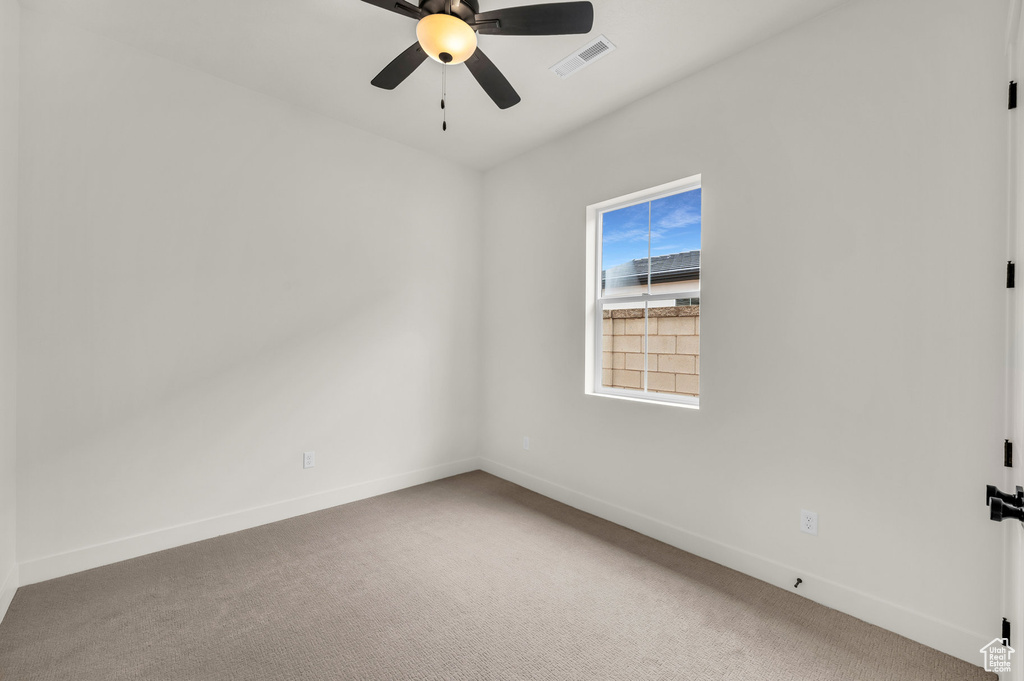 Spare room with ceiling fan and carpet flooring