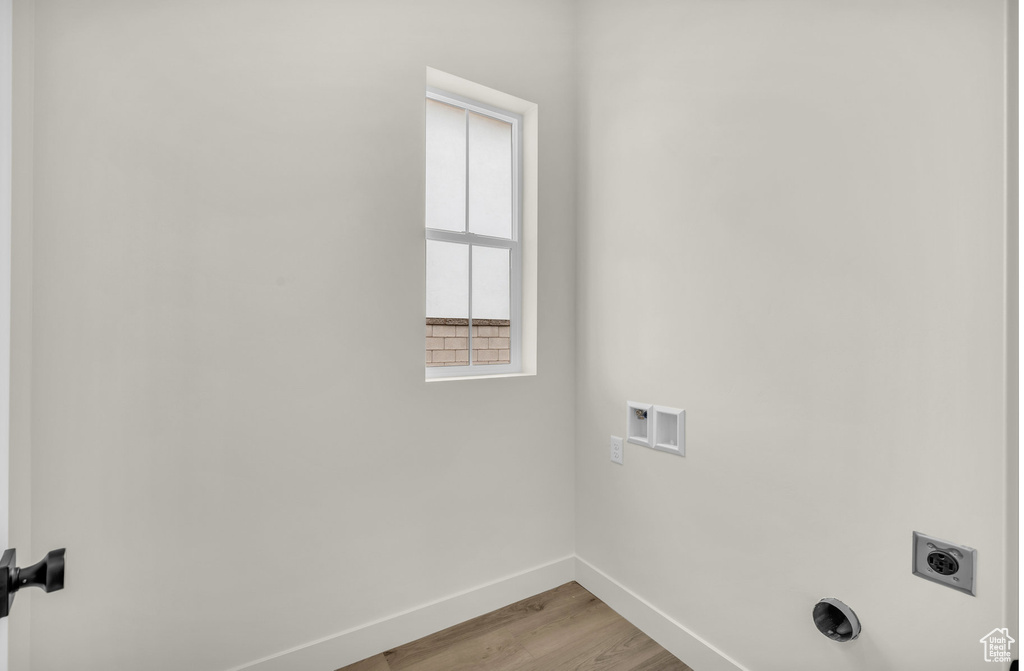 Laundry area featuring hookup for a washing machine, light hardwood / wood-style floors, and hookup for an electric dryer