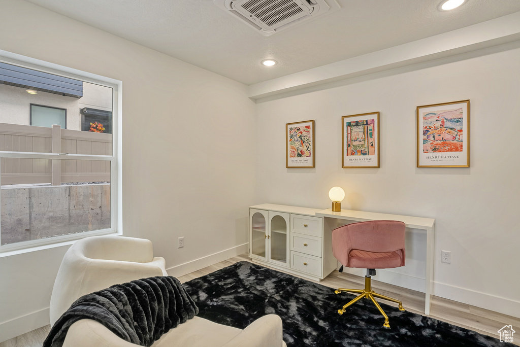 Office space featuring built in desk and light hardwood / wood-style floors