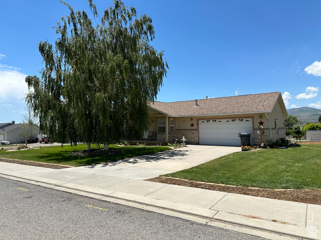 View of front of home featuring a front yard and a garage