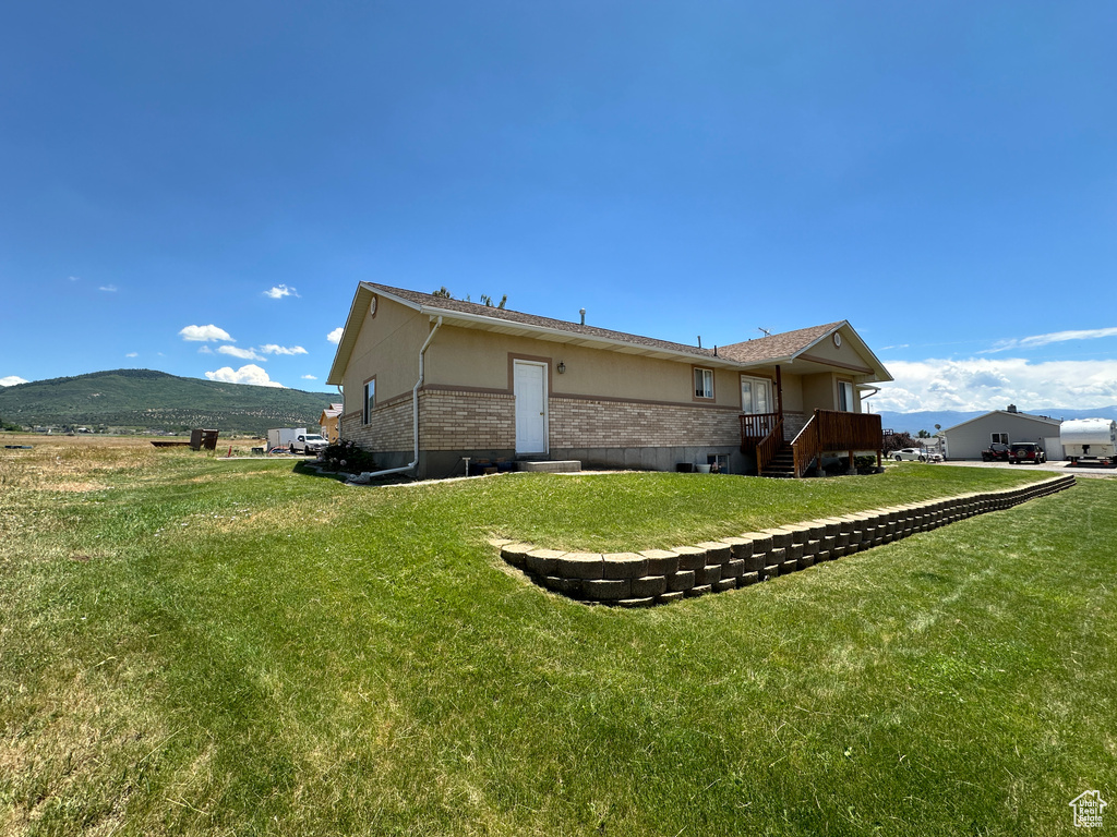 View of home's exterior with a lawn and a mountain view