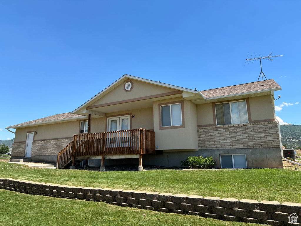 View of front of property with a front lawn and a wooden deck