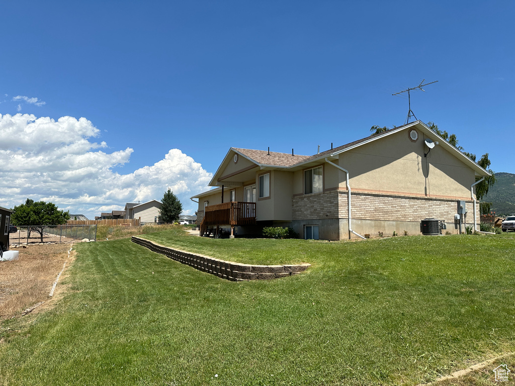 View of side of home with a lawn and central AC unit