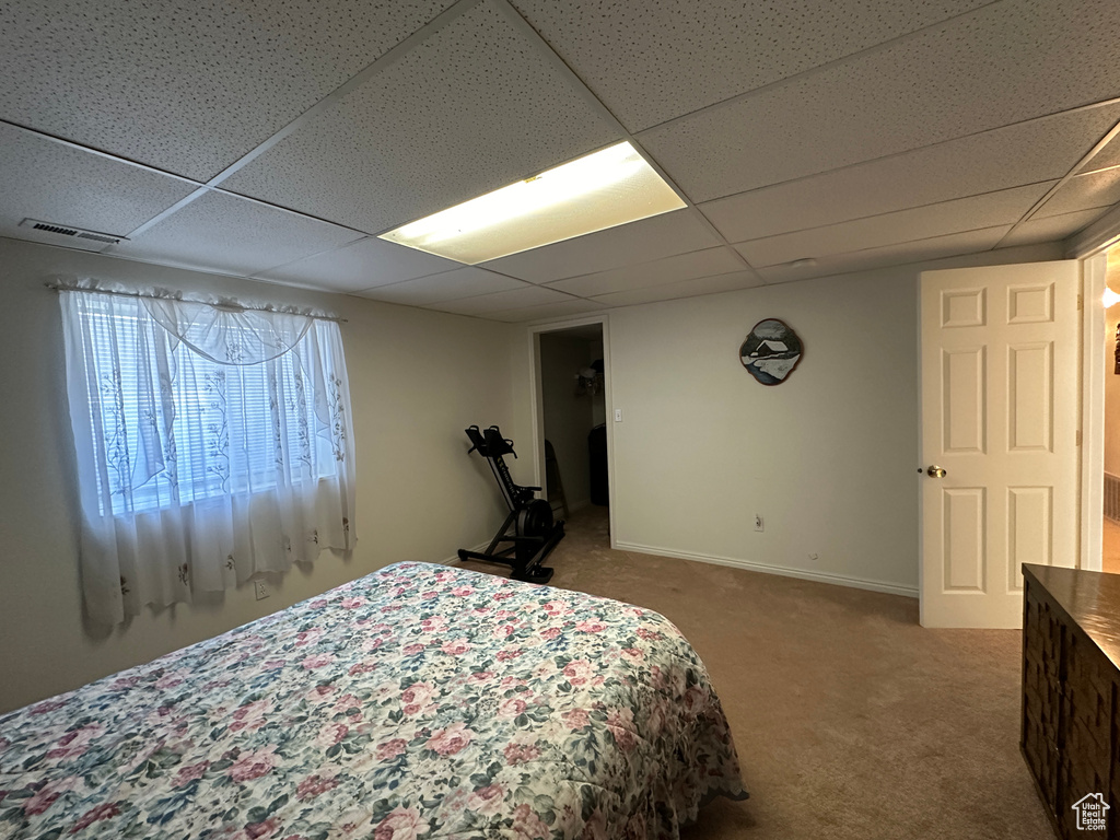 Bedroom with carpet floors and a drop ceiling