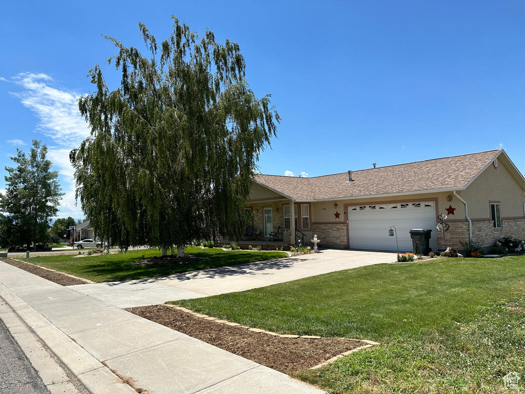 View of front facade featuring a garage and a front yard