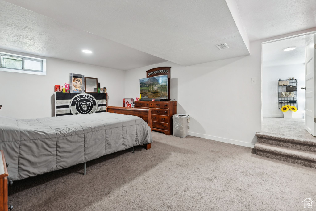 Bedroom with a textured ceiling and carpet