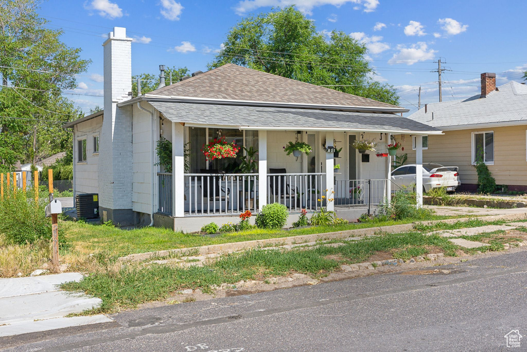 View of front of home with central AC unit and a porch