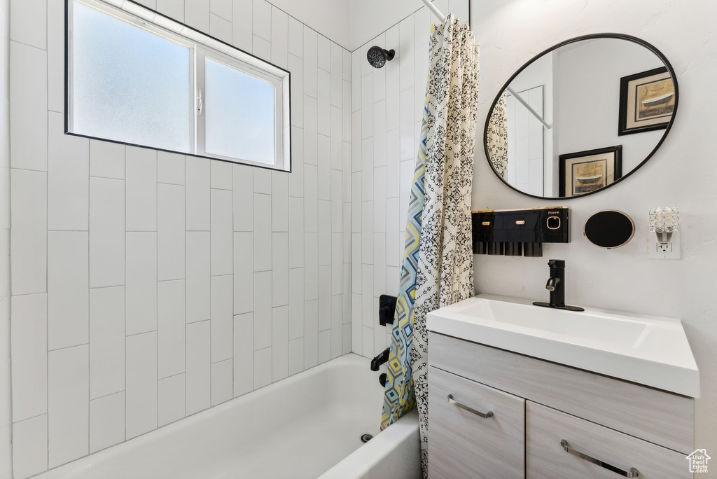 Bathroom with shower / bathtub combination with curtain and large vanity