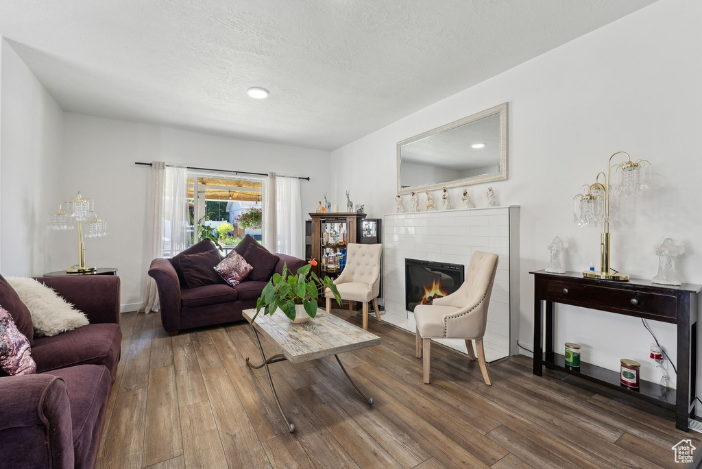 Living room with a brick fireplace and dark wood-type flooring