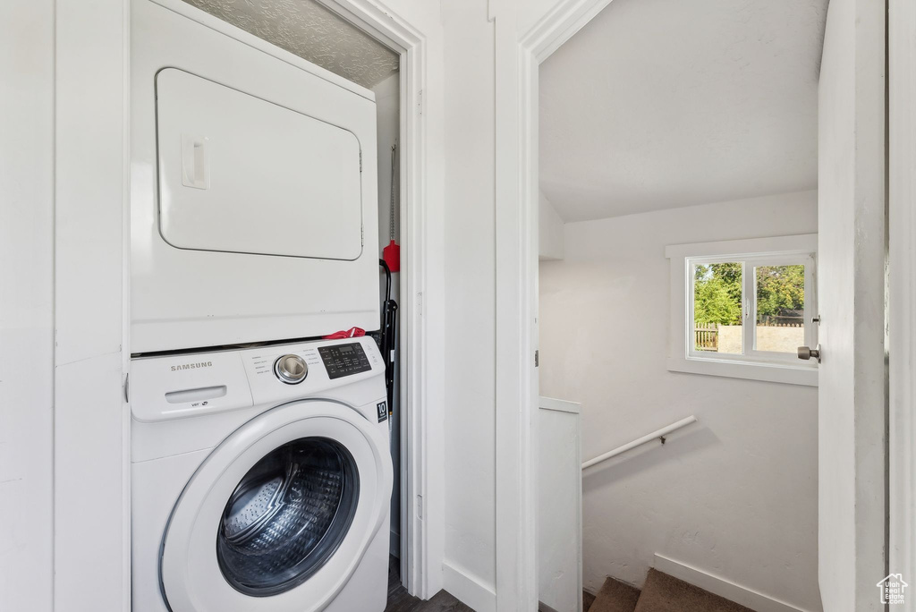 Clothes washing area featuring stacked washer and dryer