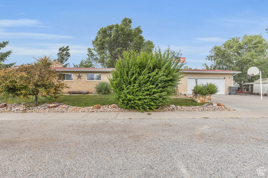 Ranch-style house featuring a garage and a front yard