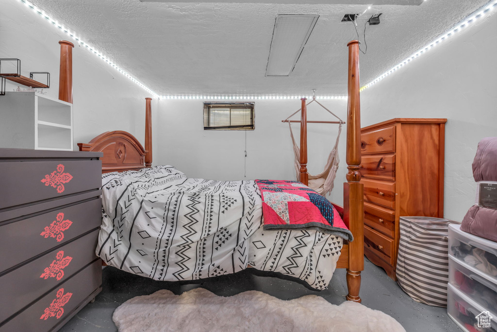 Bedroom featuring concrete floors and a textured ceiling