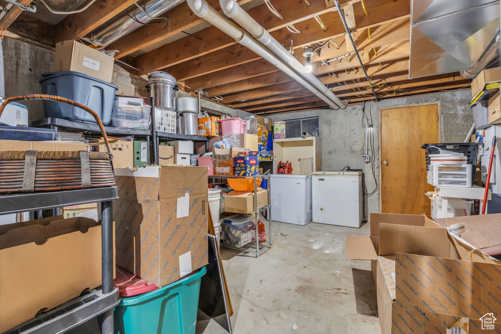 Basement with white refrigerator and refrigerator