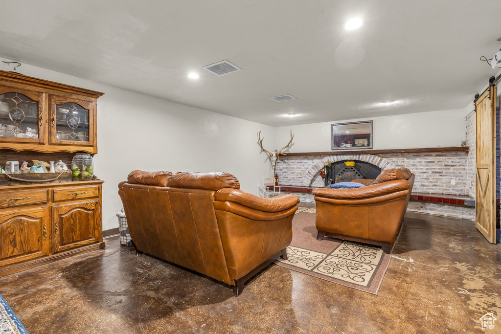 Living room featuring a barn door and brick wall