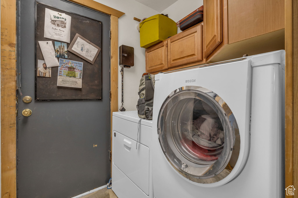 Laundry room with washing machine and clothes dryer and cabinets