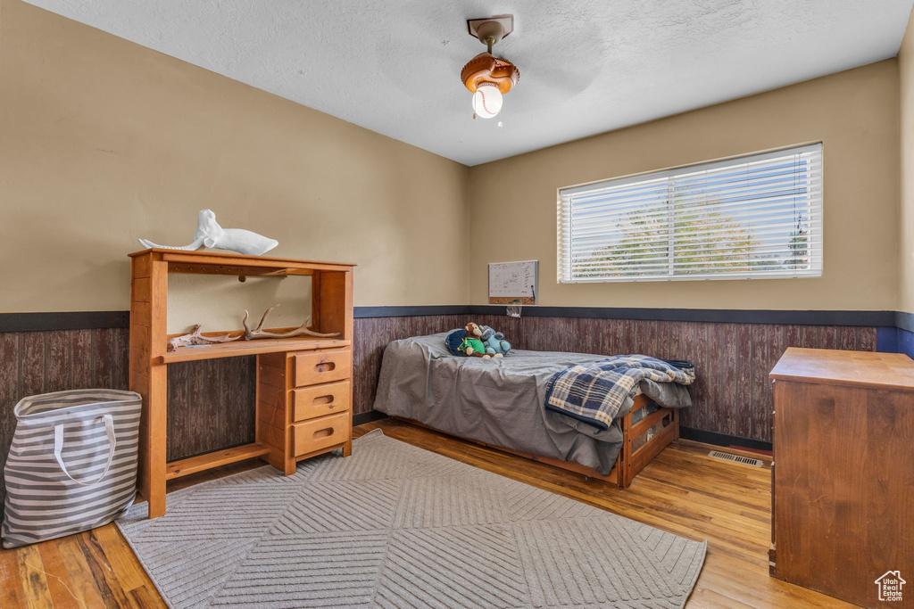 Bedroom with hardwood / wood-style floors and ceiling fan