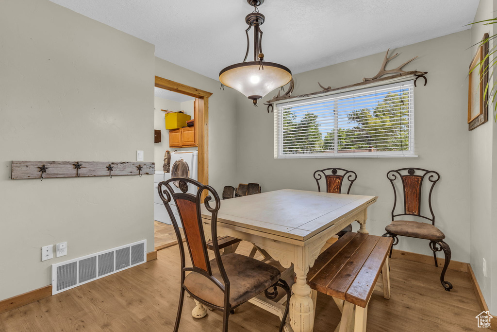 Dining area featuring washer and clothes dryer and light hardwood / wood-style floors