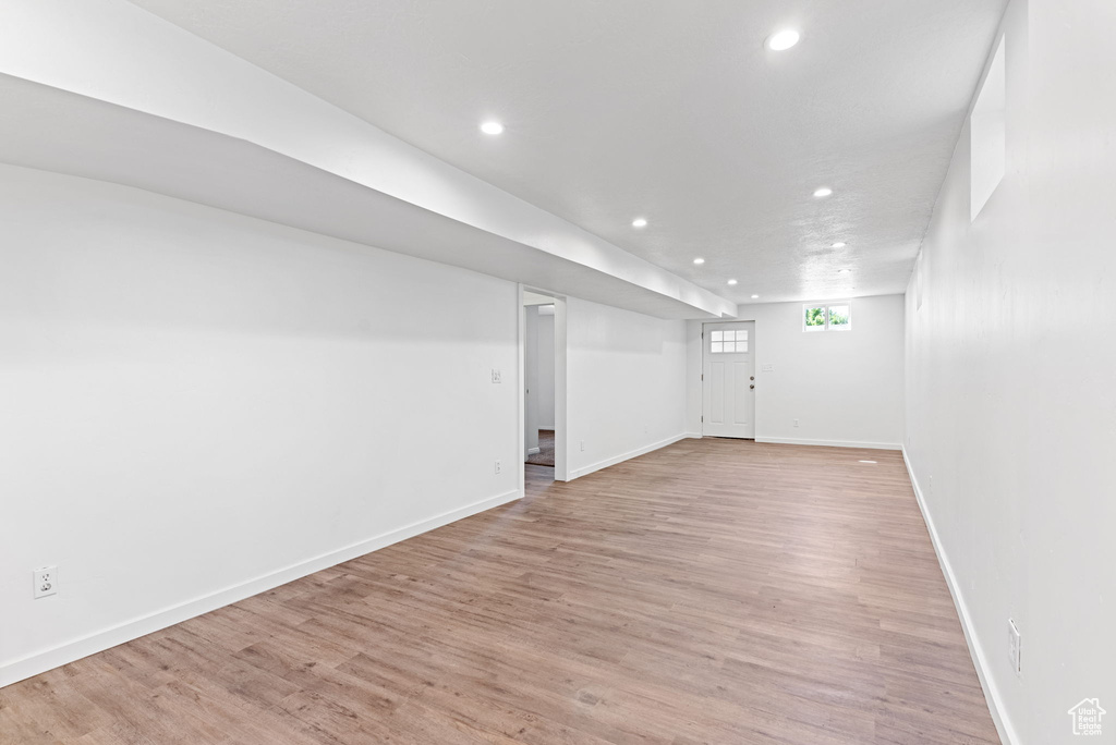 Basement with light hardwood / wood-style flooring