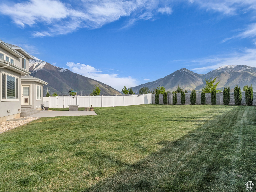 View of yard featuring a patio, a fenced backyard, a mountain view, and entry steps