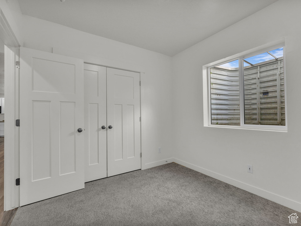 Unfurnished bedroom featuring baseboards, carpet floors, and a closet