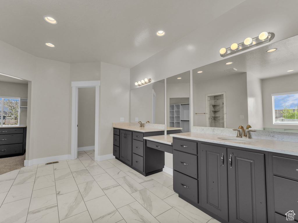 Full bath featuring two vanities, a sink, baseboards, marble finish floor, and recessed lighting