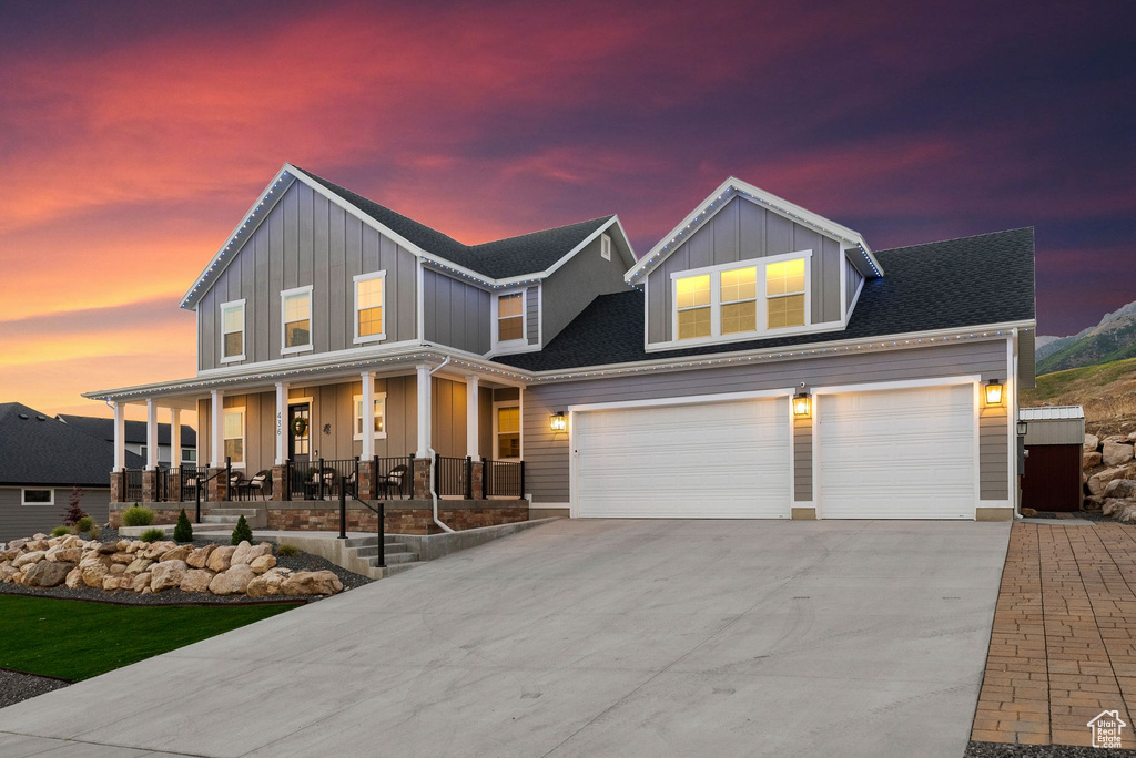 View of front of property featuring a garage and a porch