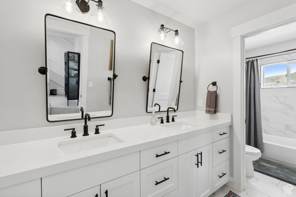 Full bathroom featuring dual bowl vanity, toilet, tile floors, and shower / tub combo with curtain