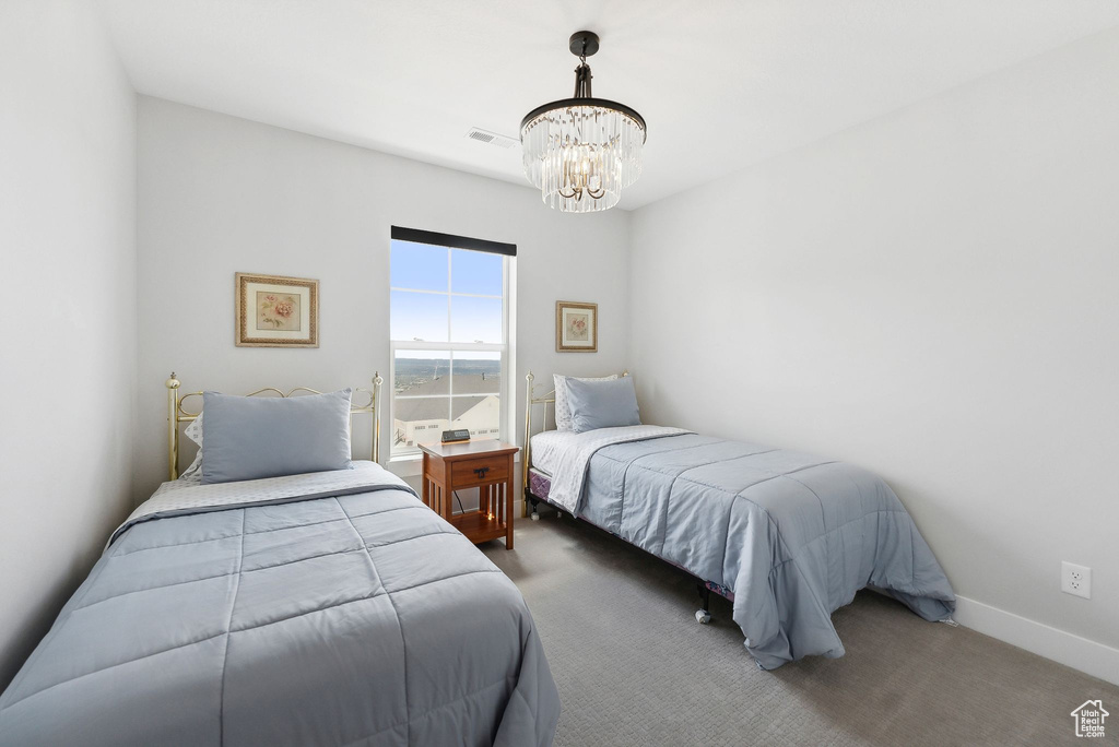 Carpeted bedroom with a chandelier