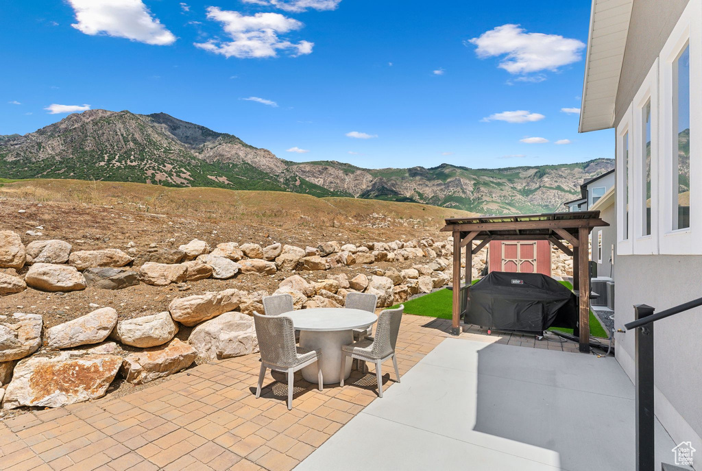 View of patio with a mountain view and a grill