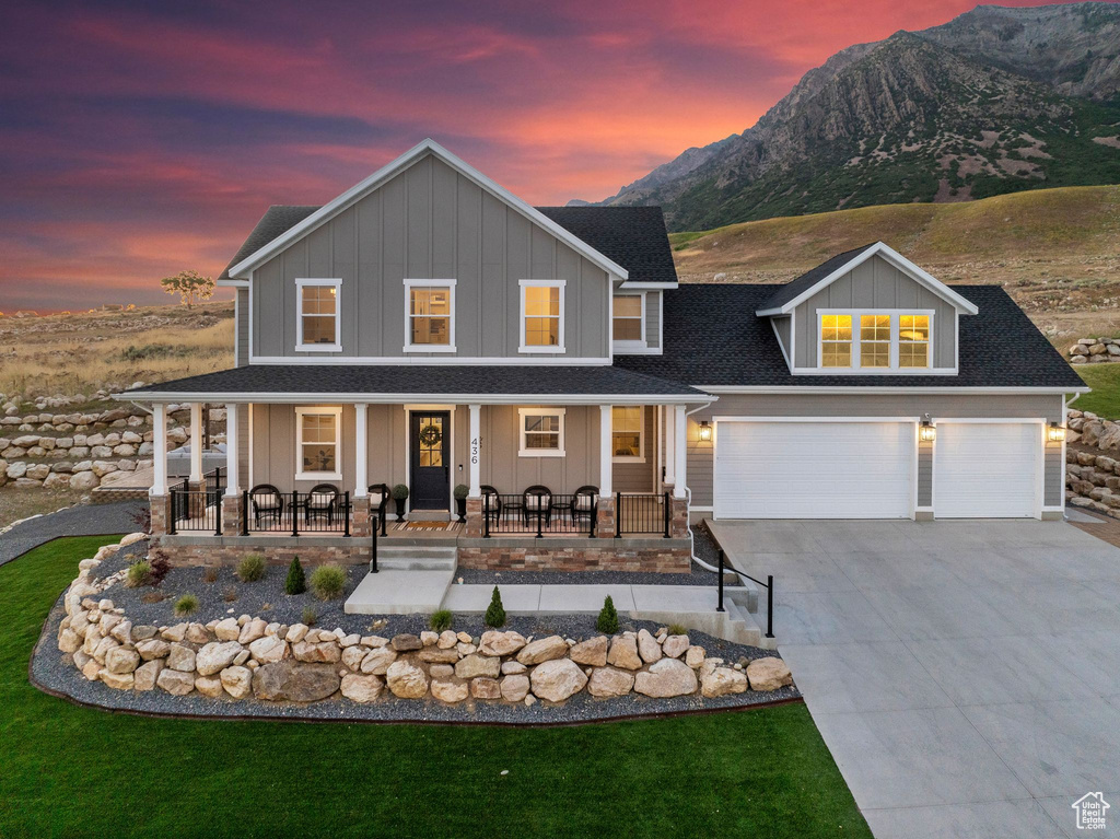 View of front facade with a garage, a mountain view, and a porch