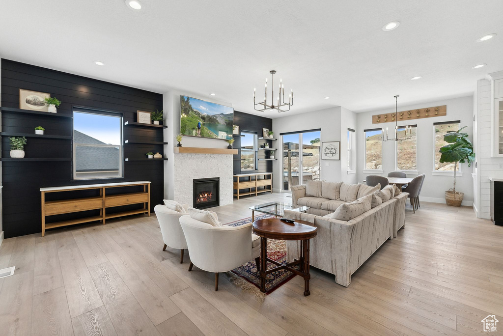 Living room with a notable chandelier and light hardwood / wood-style flooring