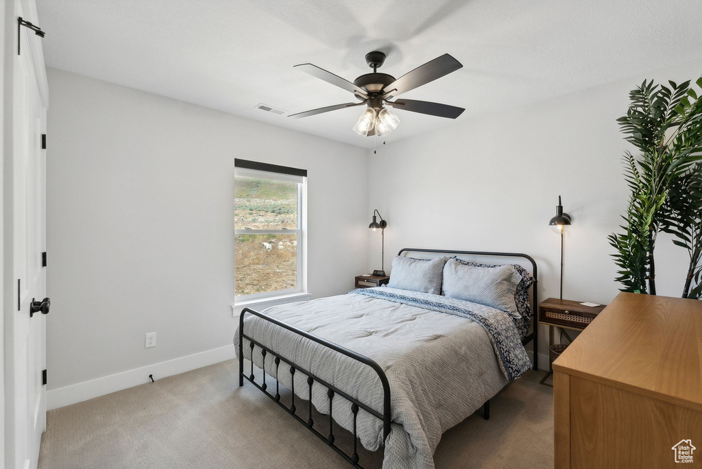 Carpeted bedroom with ceiling fan