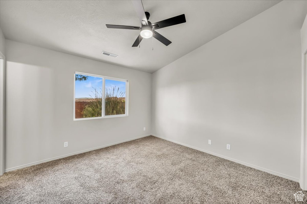 Spare room with carpet flooring, vaulted ceiling, and ceiling fan