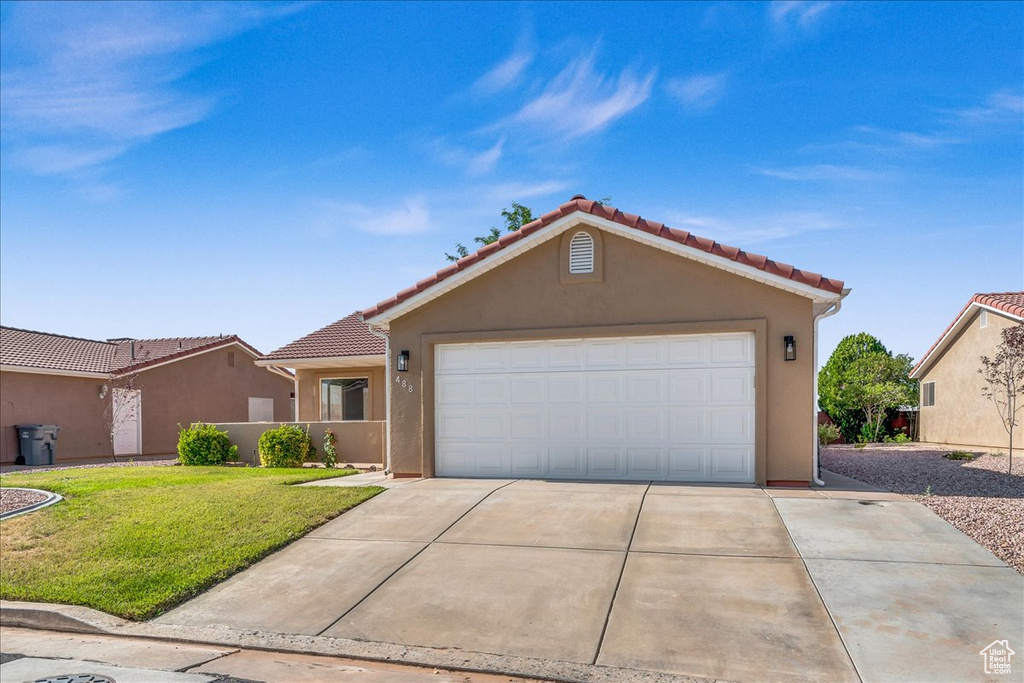 View of front of property with a front yard and a garage