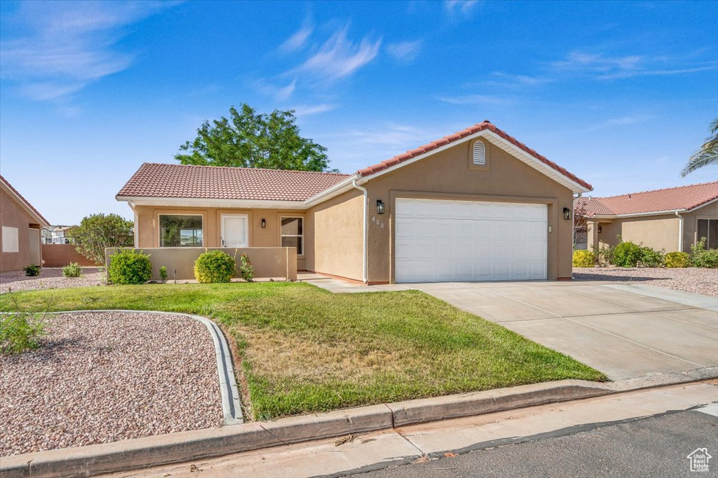 View of front of home with a front lawn and a garage