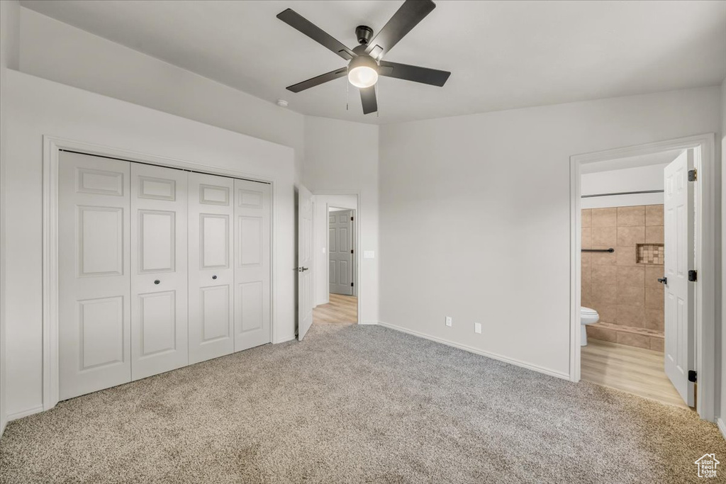 Unfurnished bedroom with a closet, ensuite bathroom, ceiling fan, and light colored carpet