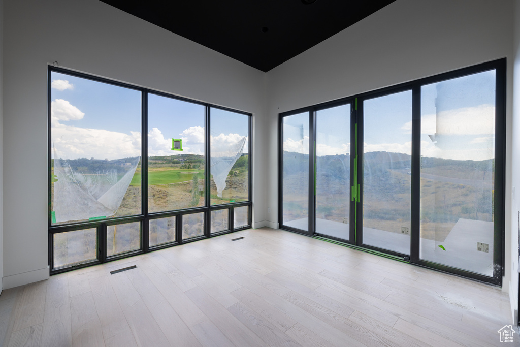 Spare room with a mountain view and light hardwood / wood-style floors