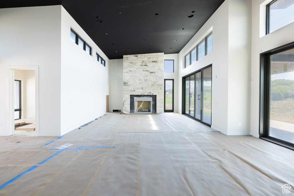 Unfurnished living room with a fireplace and a high ceiling