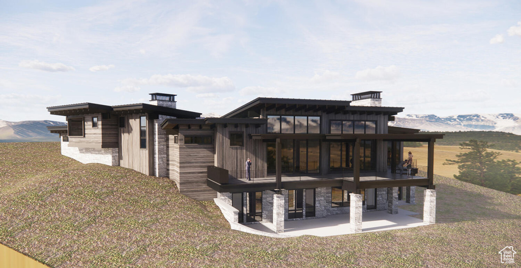 Rear view of house featuring a mountain view, a patio area, a balcony, and a lawn